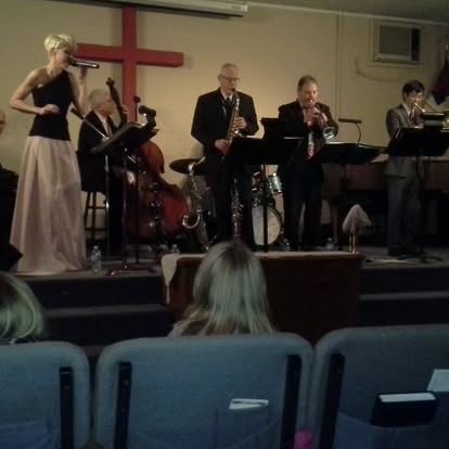 Singer and jazz ensemble performing inside Open Arms Church in 2014